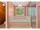 Bright bathroom features a soaking tub under a window and a separate glass shower at 619 Lovinggood Trl, Woodstock, GA 30189