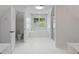 Bright bathroom with soaking tub, glass shower, and window with plantation shutters at 619 Lovinggood Trl, Woodstock, GA 30189