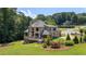 Stunning traditional home featuring a spacious deck and lush green lawn surrounded by mature trees at 619 Lovinggood Trl, Woodstock, GA 30189