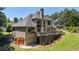 The exterior view of the home shows a spacious back deck, manicured lawn, and access to the garage at 619 Lovinggood Trl, Woodstock, GA 30189