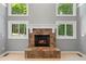 Stone fireplace with a white mantle is surrounded by windows, letting in natural light at 619 Lovinggood Trl, Woodstock, GA 30189