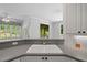 Close up on sink and gray countertops with white cabinets and view to breakfast room at 619 Lovinggood Trl, Woodstock, GA 30189