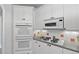 Updated kitchen features white cabinets, tile backsplash, and modern appliances at 619 Lovinggood Trl, Woodstock, GA 30189
