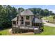 Expansive rear of home featuring large windows, a deck for entertaining, and lush green lawn at 619 Lovinggood Trl, Woodstock, GA 30189