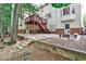 Backyard with patio, wooden steps, retaining wall, and a built-in fire pit area at 10575 Tuxford Dr, Alpharetta, GA 30022