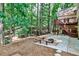 Landscaped backyard featuring a patio, fire pit, and tiered deck, with lush foliage at 10575 Tuxford Dr, Alpharetta, GA 30022