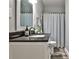 Modern bathroom featuring a vanity with dark countertops, a shower with a curtain, and stylish flooring at 10575 Tuxford Dr, Alpharetta, GA 30022
