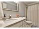 Clean bathroom with marble counters, white cabinets, and shower with curtain at 10575 Tuxford Dr, Alpharetta, GA 30022