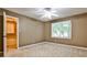 Neutral bedroom featuring a ceiling fan, closet, carpet, and a window for natural light at 10575 Tuxford Dr, Alpharetta, GA 30022