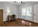 Cozy bedroom with natural light and hardwood floors, featuring a desk for work or study at 10575 Tuxford Dr, Alpharetta, GA 30022