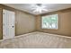 Neutral bedroom featuring a ceiling fan, closet, carpet, and a window for natural light at 10575 Tuxford Dr, Alpharetta, GA 30022