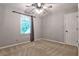 Neutral bedroom featuring a ceiling fan, closet, carpet, and a window for natural light at 10575 Tuxford Dr, Alpharetta, GA 30022