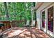 Outdoor deck with grill, chairs, and a door, surrounded by trees at 10575 Tuxford Dr, Alpharetta, GA 30022