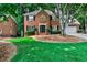 Beautiful brick home featuring manicured lawn, shade trees, and an attached garage at 10575 Tuxford Dr, Alpharetta, GA 30022