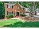 Traditional two-story brick home with a lush green lawn and mature trees at 10575 Tuxford Dr, Alpharetta, GA 30022