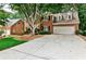 Charming two-story red brick home with a wide driveway and mature landscaping, offering great curb appeal at 10575 Tuxford Dr, Alpharetta, GA 30022