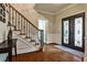 Welcoming foyer features hardwood floors, wrought iron staircase, and decorative front door at 10575 Tuxford Dr, Alpharetta, GA 30022