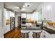 Bright kitchen features white cabinets, granite countertops, stainless steel appliances, and a breakfast bar at 10575 Tuxford Dr, Alpharetta, GA 30022