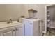Functional laundry room with sink, cabinets, and washer at 10575 Tuxford Dr, Alpharetta, GA 30022