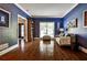 Spacious living room boasting hardwood floors, blue walls, large windows, and an open floor plan at 10575 Tuxford Dr, Alpharetta, GA 30022