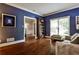 Cozy living room with hardwood floors, blue walls, and large windows overlooking the yard at 10575 Tuxford Dr, Alpharetta, GA 30022