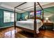 Spacious main bedroom with a four-poster bed, hardwood floors, and ample natural light at 10575 Tuxford Dr, Alpharetta, GA 30022
