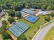 A picturesque aerial view of community tennis courts nestled among lush trees and greenery at 1125 Fairview Club Cir, Dacula, GA 30019