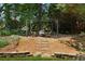 Backyard fire pit area with a stone path, wooden chairs, and lush landscaping at 1125 Fairview Club Cir, Dacula, GA 30019