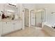 Bathroom features a tub, glass shower, and white cabinets and tile at 1125 Fairview Club Cir, Dacula, GA 30019