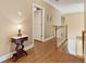 Bright hallway with hardwood floors and white trim leads to a door and staircase at 1125 Fairview Club Cir, Dacula, GA 30019