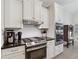 Close up of kitchen area featuring modern appliances, white cabinets, and tile backsplash at 1125 Fairview Club Cir, Dacula, GA 30019