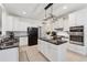 Bright kitchen features white cabinets, black countertops and appliances, and a stylish island at 1125 Fairview Club Cir, Dacula, GA 30019