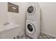 Modern laundry room with stacked washer and dryer units and stylish patterned tile flooring at 1125 Fairview Club Cir, Dacula, GA 30019