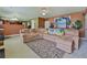 Inviting living room featuring a large sectional sofa, kitchen view, and bright natural light at 1441 Saint George Pl, Conyers, GA 30012