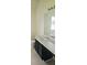 Bathroom with black vanity, white sink, and large mirror above at 116 Ventura Trl, Stockbridge, GA 30281