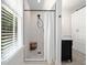 Shower with white tiled walls, gray floor, and wood stool at 161 N Barton St, Norcross, GA 30071