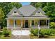 Quaint yellow two-story home with a welcoming front porch and an American flag displayed at 161 N Barton St, Norcross, GA 30071