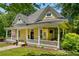Quaint yellow home with a charming porch and beautifully landscaped yard at 161 N Barton St, Norcross, GA 30071