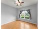 Bedroom with hardwood floors, ceiling fan, and view of the front yard at 2323 Blackberry Ct, Snellville, GA 30078