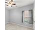 Bedroom with gray walls, ceiling fan, and view to the front yard through large window at 2323 Blackberry Ct, Snellville, GA 30078