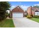 Brick home featuring a green lawn, mature landscaping and two car garage at 2323 Blackberry Ct, Snellville, GA 30078