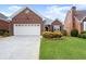 Charming brick home featuring a two-car garage, manicured lawn, and mature landscaping at 2323 Blackberry Ct, Snellville, GA 30078