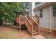 Exterior view of back of house with raised wooden deck and stairs to the lawn at 241 Lost Lake Way, Villa Rica, GA 30180