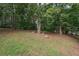 The backyard offers a lush lawn area and beautiful surrounding trees, providing an ideal backdrop for outdoor activities at 241 Lost Lake Way, Villa Rica, GA 30180