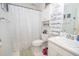 Well lit bathroom with toilet, sink, shower curtain, and storage shelf at 241 Lost Lake Way, Villa Rica, GA 30180