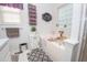 Well-lit bathroom featuring a tub, vanity, and decorative accents with a window at 241 Lost Lake Way, Villa Rica, GA 30180