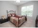 Cozy bedroom features a metal frame bed, carpeted floor and window with blinds at 241 Lost Lake Way, Villa Rica, GA 30180