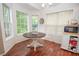 Bright breakfast nook features a round table, wood floors, and large windows offering green views at 241 Lost Lake Way, Villa Rica, GA 30180