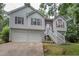 This two-story home features a two-car garage, traditional windows, a covered entryway, and manicured landscaping at 241 Lost Lake Way, Villa Rica, GA 30180