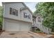 Charming exterior showing the two-car garage, siding, stone accents, and staircase leading to the front door at 241 Lost Lake Way, Villa Rica, GA 30180